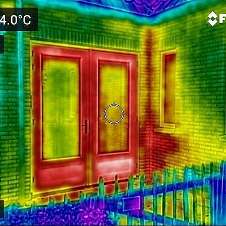 Warmtebeeldfoto van een huis. Verschillende kleuren geven de temperatuur aan. 